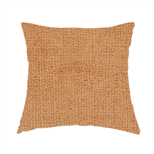 The fabric used to create this handmade cushion is a textured fabric swatch in a warm terracotta or burnt orange colour. The material features a dense, uniform nubby weave with a soft, matte appearance, resembling chenille or bouclé cloth.
