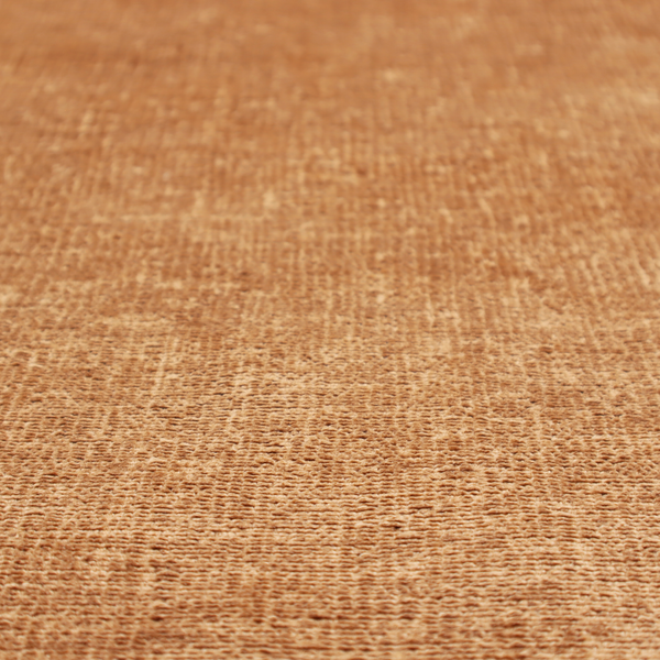 A textured fabric swatch in a warm terracotta or burnt orange colour. The material features a dense, uniform nubby weave with a soft, matte appearance, resembling chenille or bouclé cloth.