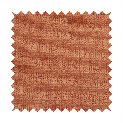 A textured fabric swatch in a rich rust or burnt sienna colour. The material features a dense, uniform nubby weave with subtle dark undertones and shading, giving the soft surface a multi-tonal, warm appearance.