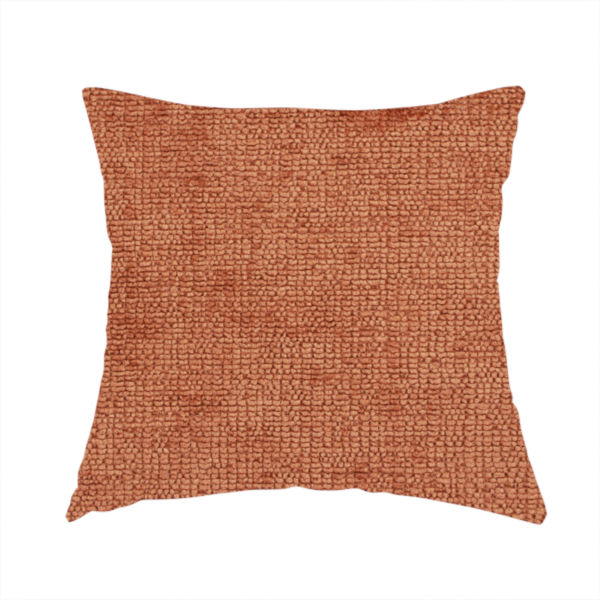 The fabric used to create this handmade cushion is a textured fabric swatch in a rich rust or burnt sienna colour. The material features a dense, uniform nubby weave with subtle dark undertones and shading, giving the soft surface a multi-tonal, warm appearance.