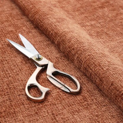 A textured fabric swatch in a rich rust or burnt sienna colour. The material features a dense, uniform nubby weave with subtle dark undertones and shading, giving the soft surface a multi-tonal, warm appearance.