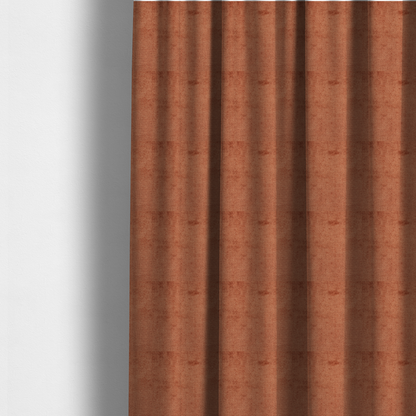 The fabric used to create these made-to-measure curtains is a textured fabric swatch in a rich rust or burnt sienna colour. The material features a dense, uniform nubby weave with subtle dark undertones and shading, giving the soft surface a multi-tonal, warm appearance.