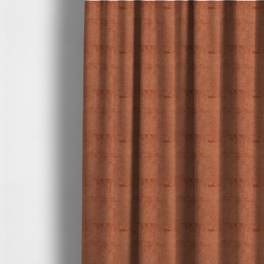 The fabric used to create these made-to-measure curtains is a textured fabric swatch in a rich rust or burnt sienna colour. The material features a dense, uniform nubby weave with subtle dark undertones and shading, giving the soft surface a multi-tonal, warm appearance.