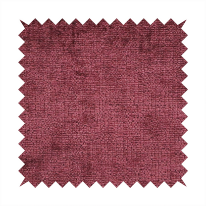 A textured fabric swatch in a rich berry red, burgundy, or mauve colour. The material features a dense, uniform nubby weave with subtle dark variations and shading, giving the soft surface a multi-tonal, deep appearance.