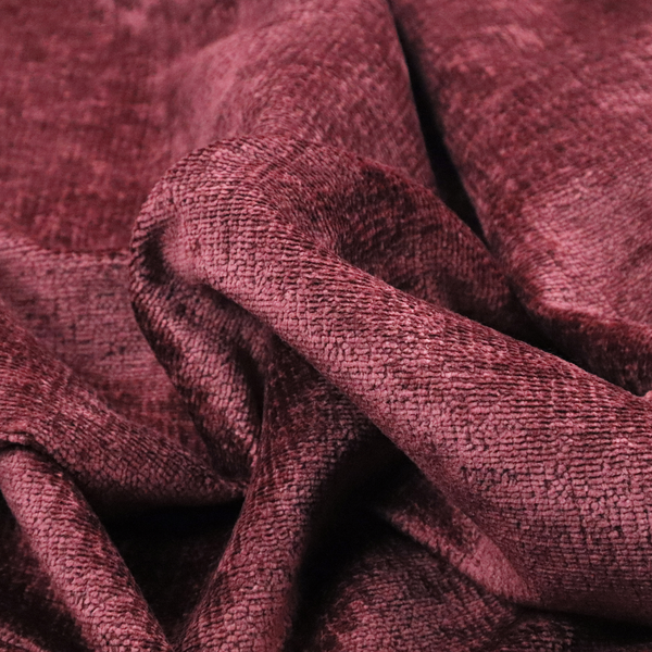 A textured fabric swatch in a rich berry red, burgundy, or mauve colour. The material features a dense, uniform nubby weave with subtle dark variations and shading, giving the soft surface a multi-tonal, deep appearance.