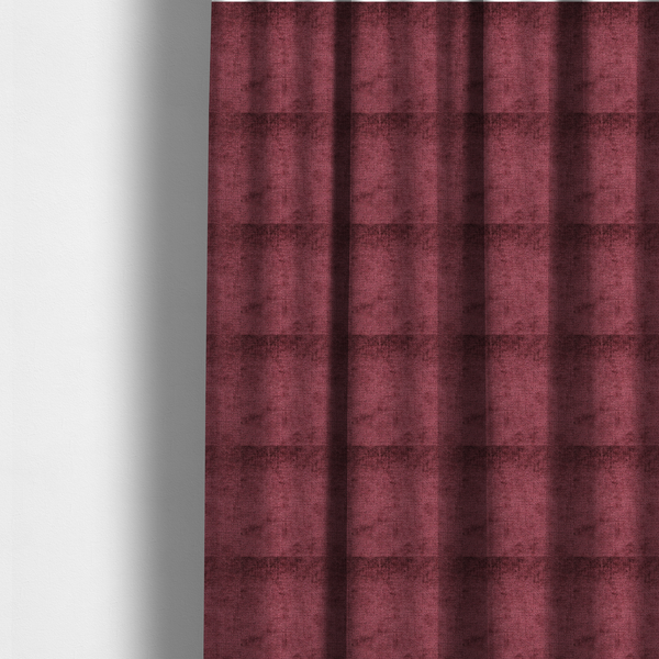 The fabric used to create these made-to-measure curtains is a textured fabric swatch in a rich berry red, burgundy, or mauve colour. The material features a dense, uniform nubby weave with subtle dark variations and shading, giving the soft surface a multi-tonal, deep appearance.