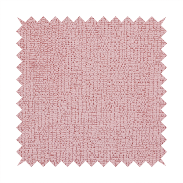 A textured fabric swatch in a soft, dusty pink or rose colour. The material features a dense, uniform nubby weave with a matte finish, creating a gentle and welcoming appearance.