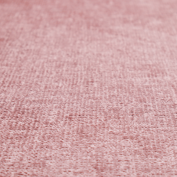 A textured fabric swatch in a soft, dusty pink or rose colour. The material features a dense, uniform nubby weave with a matte finish, creating a gentle and welcoming appearance.