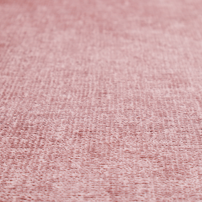A textured fabric swatch in a soft, dusty pink or rose colour. The material features a dense, uniform nubby weave with a matte finish, creating a gentle and welcoming appearance.