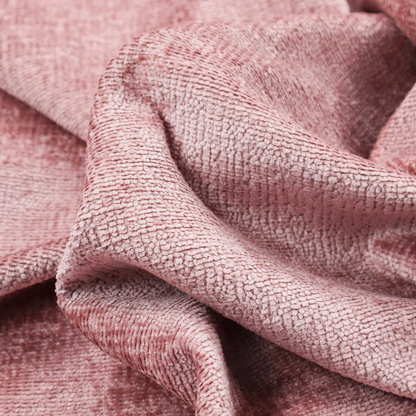 A textured fabric swatch in a soft, dusty pink or rose colour. The material features a dense, uniform nubby weave with a matte finish, creating a gentle and welcoming appearance.