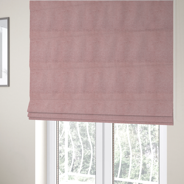 The fabric used to create these Roman blinds is a textured fabric swatch in a soft, dusty pink or rose colour. The material features a dense, uniform nubby weave with a matte finish, creating a gentle and welcoming appearance.