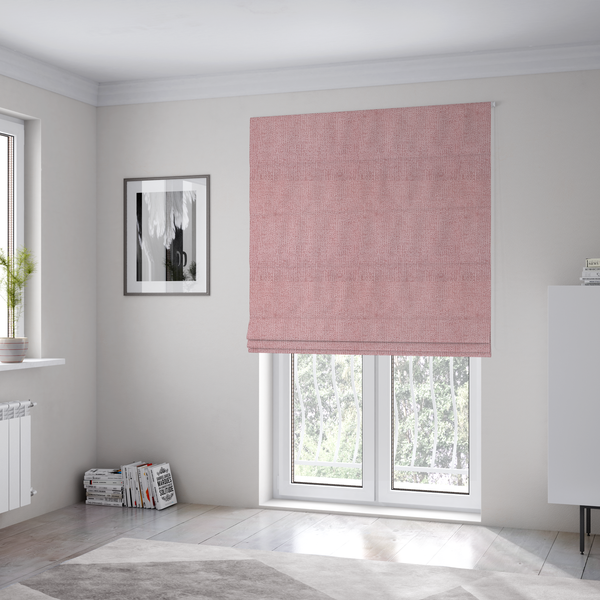 The fabric used to create these Roman blinds is a textured fabric swatch in a soft, dusty pink or rose colour. The material features a dense, uniform nubby weave with a matte finish, creating a gentle and welcoming appearance.