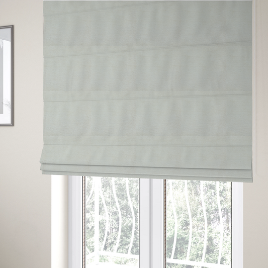 The fabric used to create these Roman blinds is a textured fabric swatch in a soft cream, ivory, or natural off-white colour. The material features a dense, uniform nubby weave with subtle warm undertones, creating a cosy and clean appearance.