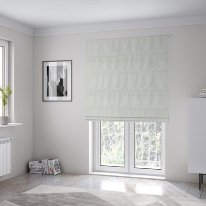 The fabric used to create these Roman blinds is a textured fabric swatch in a soft cream, ivory, or natural off-white colour. The material features a dense, uniform nubby weave with subtle warm undertones, creating a cosy and clean appearance.