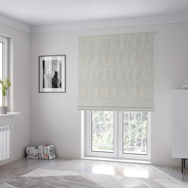 The fabric used to create these Roman blinds is a textured fabric swatch in a very pale, light beige or ecru colour. The material features a dense, uniform nubby weave with subtle neutral undertones, creating a soft, warm-toned minimalist appearance.