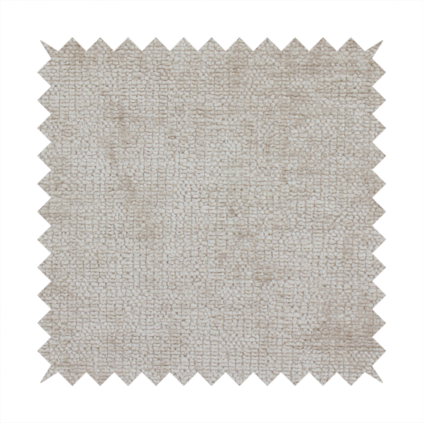 A textured fabric swatch in a light, neutral taupe or sandy beige colour. The material features a dense, uniform nubby weave with subtle horizontal striations and warm grey undertones, creating a soft, multi-tonal appearance.
