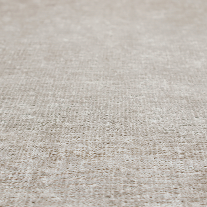 A textured fabric swatch in a light, neutral taupe or sandy beige colour. The material features a dense, uniform nubby weave with subtle horizontal striations and warm grey undertones, creating a soft, multi-tonal appearance.
