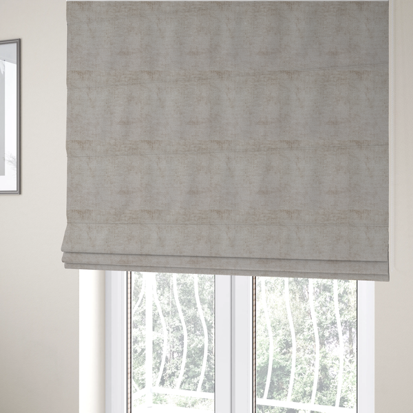 The fabric used to create these Roman blinds is a textured fabric swatch in a light, neutral taupe or sandy beige colour. The material features a dense, uniform nubby weave with subtle horizontal striations and warm grey undertones, creating a soft, multi-tonal appearance.
