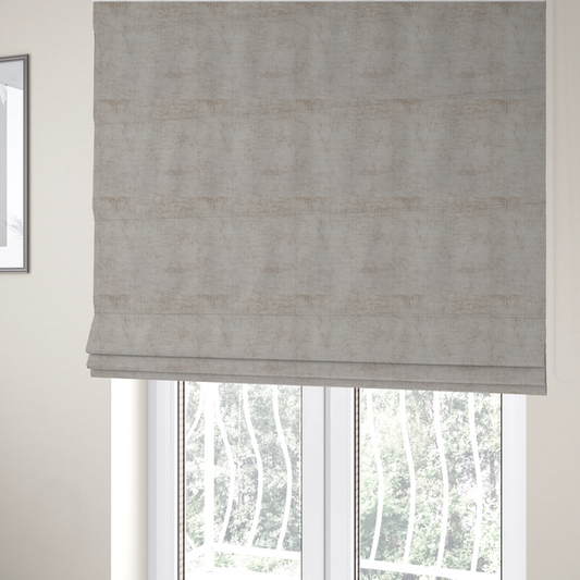The fabric used to create these Roman blinds is a textured fabric swatch in a light, neutral taupe or sandy beige colour. The material features a dense, uniform nubby weave with subtle horizontal striations and warm grey undertones, creating a soft, multi-tonal appearance.