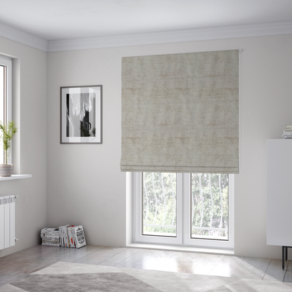 The fabric used to create these Roman blinds is a textured fabric swatch in a light, neutral taupe or sandy beige colour. The material features a dense, uniform nubby weave with subtle horizontal striations and warm grey undertones, creating a soft, multi-tonal appearance.