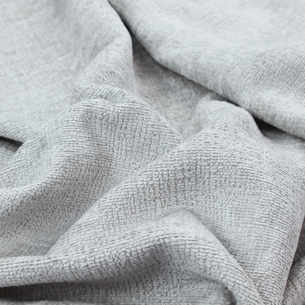 A textured fabric swatch in a very pale, light grey or silver colour. The material features a dense, uniform nubby weave with subtle neutral undertones, creating a soft, clean, and modern appearance.