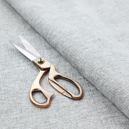 A textured fabric swatch in a very pale, light grey or silver colour. The material features a dense, uniform nubby weave with subtle neutral undertones, creating a soft, clean, and modern appearance.