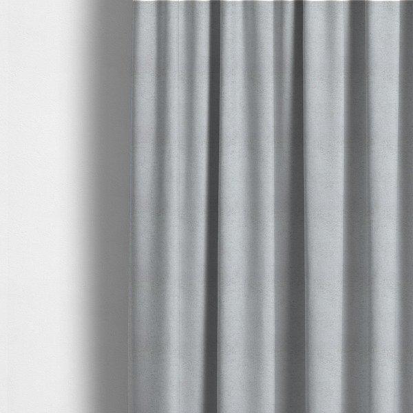 The fabric used to create these made-to-measure curtains is a textured fabric swatch in a very pale, light grey or silver colour. The material features a dense, uniform nubby weave with subtle neutral undertones, creating a soft, clean, and modern appearance.