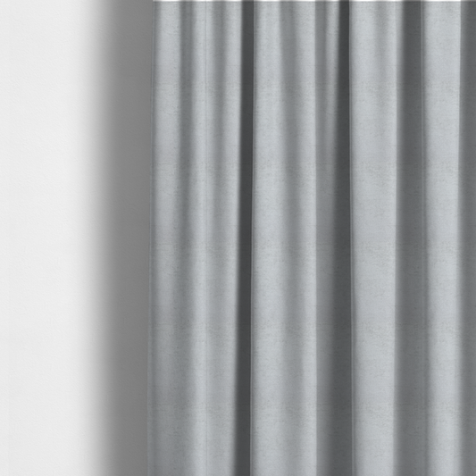 The fabric used to create these made-to-measure curtains is a textured fabric swatch in a very pale, light grey or silver colour. The material features a dense, uniform nubby weave with subtle neutral undertones, creating a soft, clean, and modern appearance.