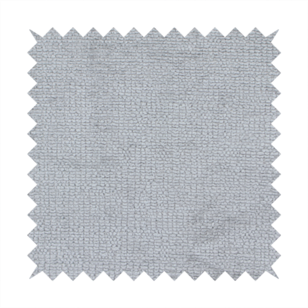 A textured fabric swatch in a cool, light-to-medium grey or stone colour. The material features a dense, uniform nubby weave with subtle horizontal shadowing, creating a soft, contemporary matte finish.