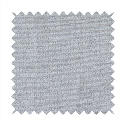 A textured fabric swatch in a cool, light-to-medium grey or stone colour. The material features a dense, uniform nubby weave with subtle horizontal shadowing, creating a soft, contemporary matte finish.