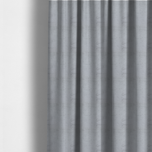 The fabric used to create these made-to-measure curtains is a textured fabric swatch in a cool, light-to-medium grey or stone colour. The material features a dense, uniform nubby weave with subtle horizontal shadowing, creating a soft, contemporary matte finish.