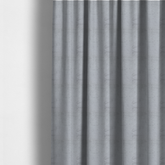 The fabric used to create these made-to-measure curtains is a textured fabric swatch in a cool, light-to-medium grey or stone colour. The material features a dense, uniform nubby weave with subtle horizontal shadowing, creating a soft, contemporary matte finish.