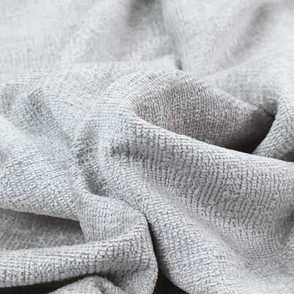 A textured fabric swatch in a very light, icy grey or pale ash colour. The material features a dense, uniform nubby weave with bright neutral tones, creating a clean, crisp, and contemporary appearance.