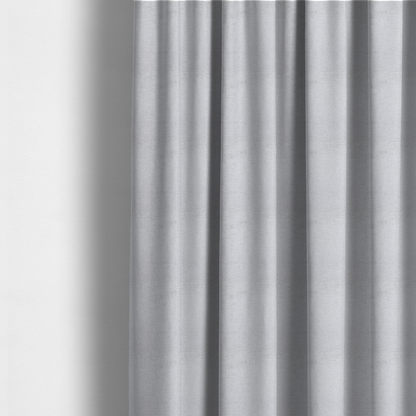 The fabric used to create these made-to-measure curtains is a textured fabric swatch in a very light, icy grey or pale ash colour. The material features a dense, uniform nubby weave with bright neutral tones, creating a clean, crisp, and contemporary appearance.