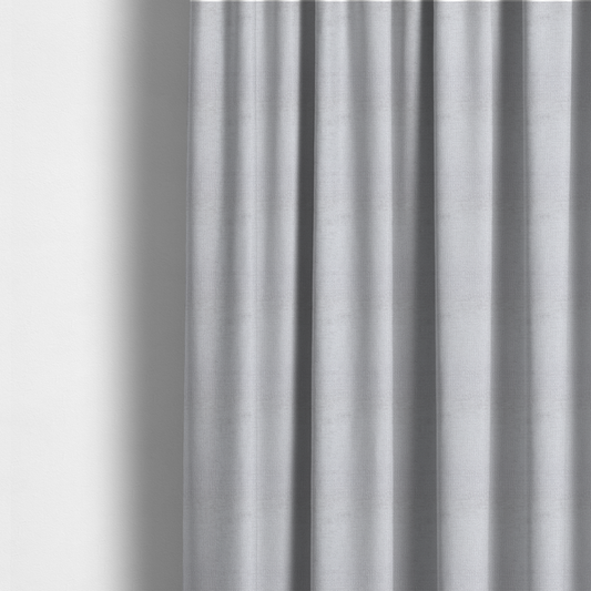 The fabric used to create these made-to-measure curtains is a textured fabric swatch in a very light, icy grey or pale ash colour. The material features a dense, uniform nubby weave with bright neutral tones, creating a clean, crisp, and contemporary appearance.