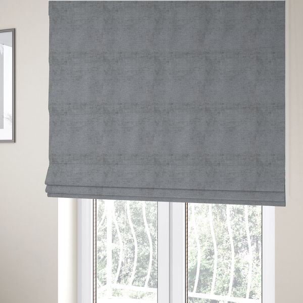The fabric used to create these Roman blinds is a textured fabric swatch in a medium grey or slate colour. The material features a dense, uniform nubby weave with subtle dark and light shading variations, creating a soft, multi-tonal contemporary look.
