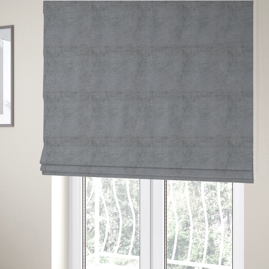 The fabric used to create these Roman blinds is a textured fabric swatch in a medium grey or slate colour. The material features a dense, uniform nubby weave with subtle dark and light shading variations, creating a soft, multi-tonal contemporary look.
