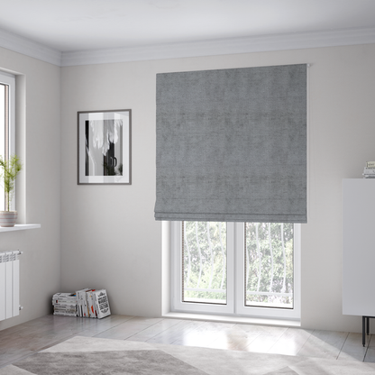 The fabric used to create these Roman blinds is a textured fabric swatch in a medium grey or slate colour. The material features a dense, uniform nubby weave with subtle dark and light shading variations, creating a soft, multi-tonal contemporary look.
