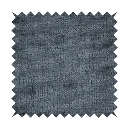 a textured fabric swatch in a dark charcoal or graphite grey colour. The material features a dense, uniform nubby weave with deep, moody undertones and subtle dark shadowing, creating a rich, contemporary appearance.