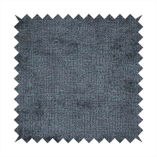 a textured fabric swatch in a dark charcoal or graphite grey colour. The material features a dense, uniform nubby weave with deep, moody undertones and subtle dark shadowing, creating a rich, contemporary appearance.