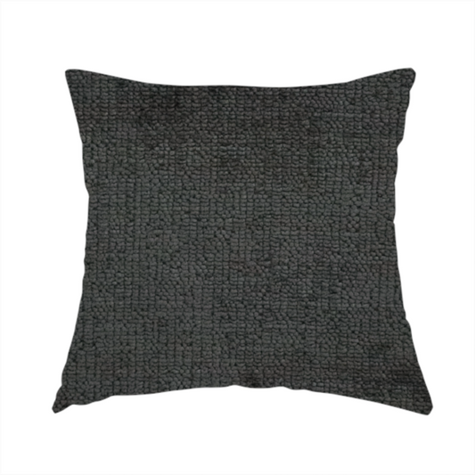The fabric used to create this handmade cushion is a textured fabric swatch in a very dark anthracite or charcoal grey colour. The material features a dense, uniform nubby weave with deep, almost black shading variations, creating a rich, moody, and sophisticated appearance.