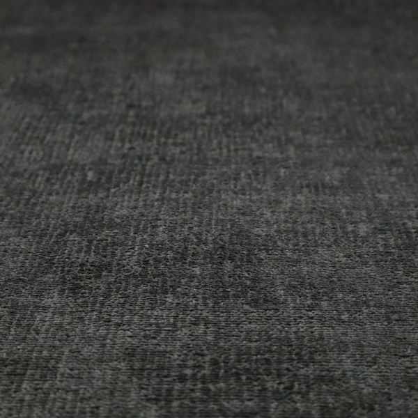 A textured fabric swatch in a very dark anthracite or charcoal grey colour. The material features a dense, uniform nubby weave with deep, almost black shading variations, creating a rich, moody, and sophisticated appearance.