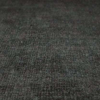 A textured fabric swatch in a very dark anthracite or charcoal grey colour. The material features a dense, uniform nubby weave with deep, almost black shading variations, creating a rich, moody, and sophisticated appearance.