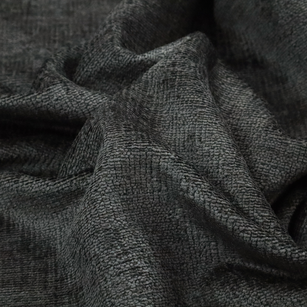 A textured fabric swatch in a very dark anthracite or charcoal grey colour. The material features a dense, uniform nubby weave with deep, almost black shading variations, creating a rich, moody, and sophisticated appearance.