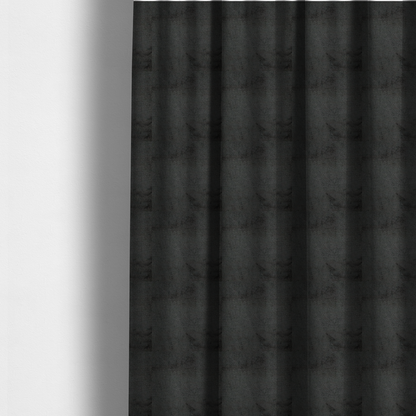 The fabric used to create these made-to-measure curtains is a textured fabric swatch in a very dark anthracite or charcoal grey colour. The material features a dense, uniform nubby weave with deep, almost black shading variations, creating a rich, moody, and sophisticated appearance.