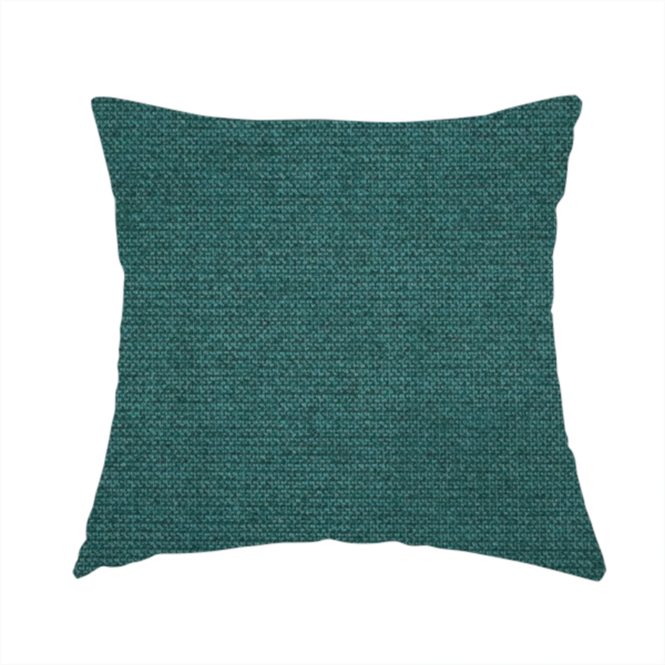 The fabric used to create this handmade cushion is a textured teal fabric with a visible tight weave.