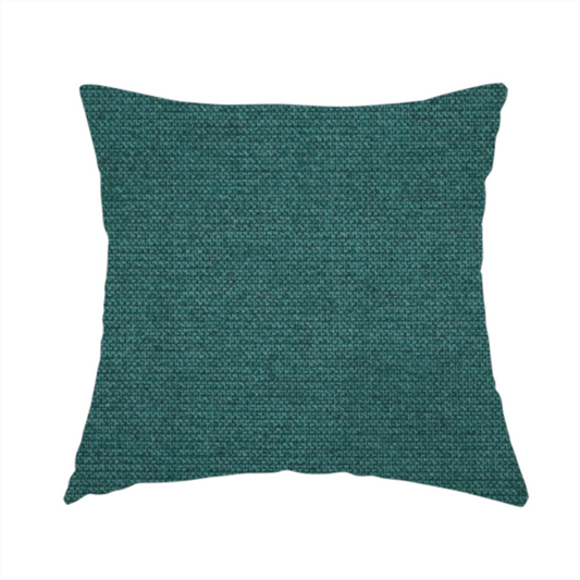 The fabric used to create this handmade cushion is a textured teal fabric with a visible tight weave.
