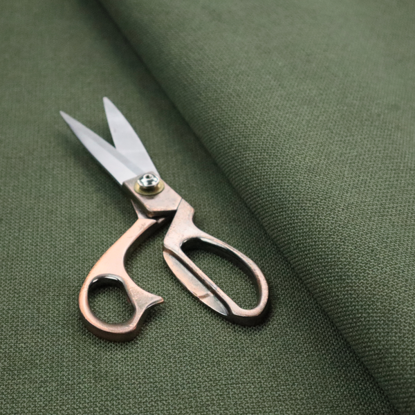 A textured moss green fabric with a tight, uniform weave.