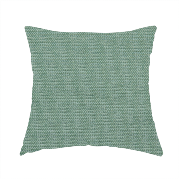 The fabric used to create this handmade cushion is a textured sage or mint green fabric with a tight, uniform weave.