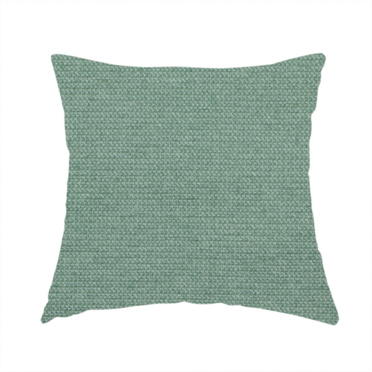 The fabric used to create this handmade cushion is a textured sage or mint green fabric with a tight, uniform weave.